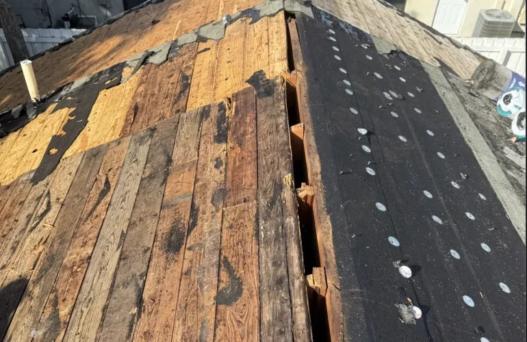 Partially repaired wooden roof with a large gap; some shingles and nails are visible on the right side.