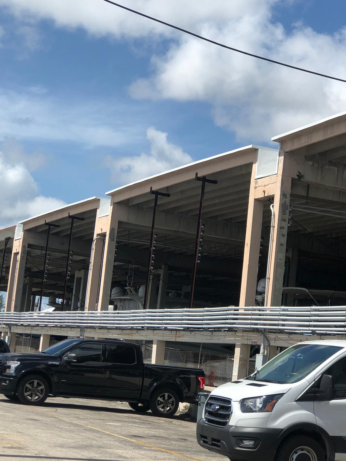 Several parked trucks in front of an industrial-looking building under a partly cloudy sky.